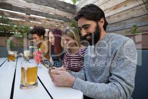 Friends using mobile phone in bar