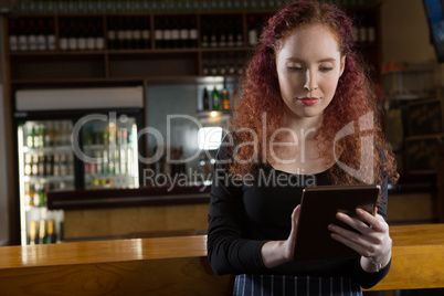 Beautiful waitress using digital tablet