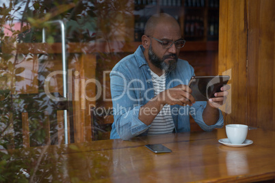 Man using digital tablet in caf