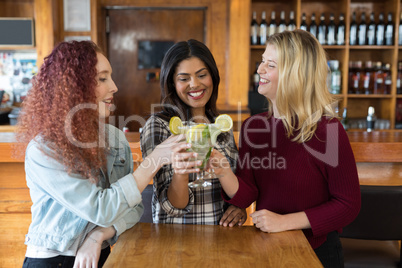 Friends toasting glass of drinks in bar