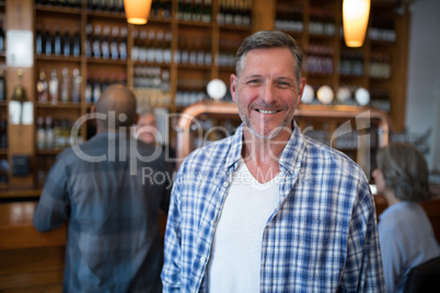 Happy man standing in bar