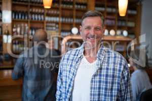 Happy man standing in bar