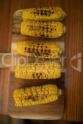 Baked baby corn on wooden tray