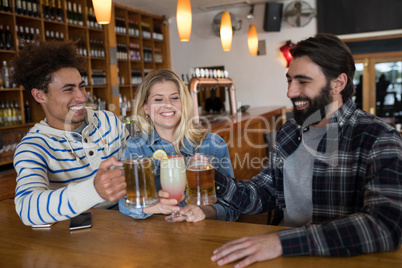 Friends toasting glass of drinks in bar