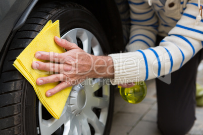Auto service staff cleaning a tyre with duster