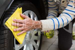 Auto service staff cleaning a tyre with duster