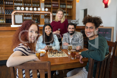 Friends having glass of beer in bar