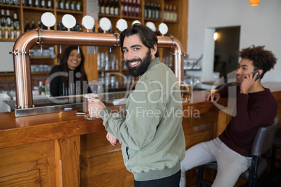 Man having glass of beer at counter in bar