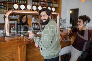 Man having glass of beer at counter in bar