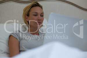 Woman using laptop on bed