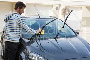 Auto service staff cleaning a car with duster