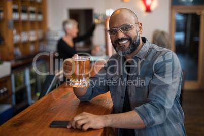 Happy man having glass of beer in bar