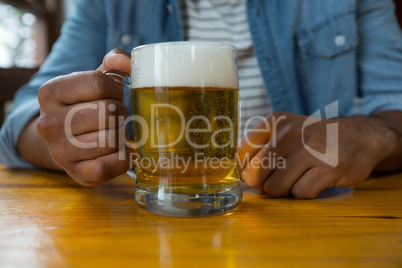 Mid section of man with glass of beer