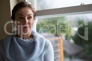 Thoughtful woman sitting near window