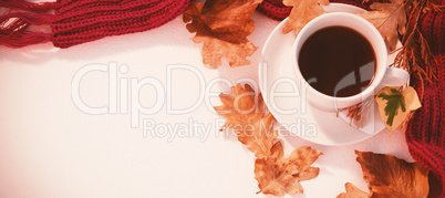 Cup of black tea with autumn leaves and woolen cloth on white background