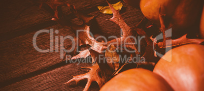 Pumpkin with autumn leaves on wooden table