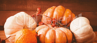 Pumpkins with plant stems on wooden table