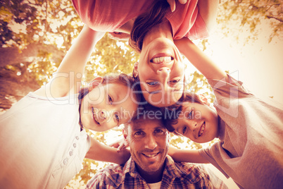 Happy family in park huddling in circle