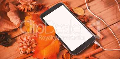 Mobile phone on wood table surround of leaf