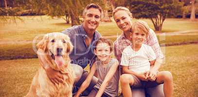 Portrait of family enjoying with dog at park