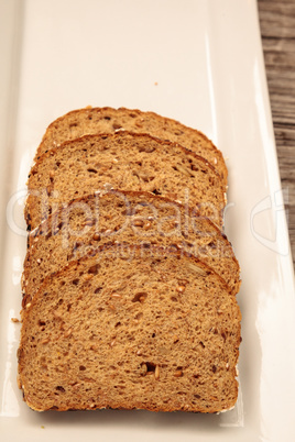 Brown multigrain bread slices on a white plate