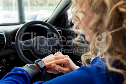 Close up of woman using smart watch in car