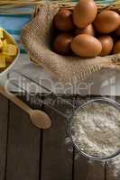 Brown eggs and flour on a wooden table