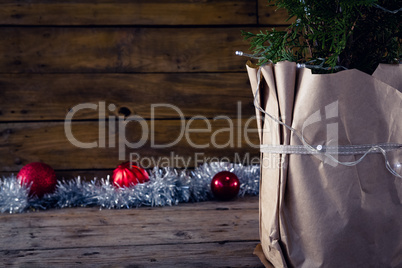 Christmas tree with decorations against wooden background