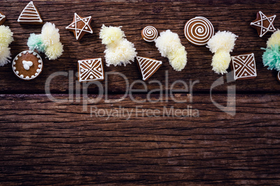 Various christmas cookies and decorations arranged on wooden plank