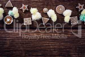 Various christmas cookies and decorations arranged on wooden plank