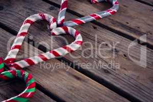 Heart shaped candy cane on wooden plank