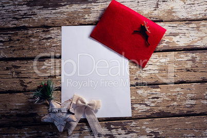 Red envelope, blank paper and christmas decorations on wooden plank