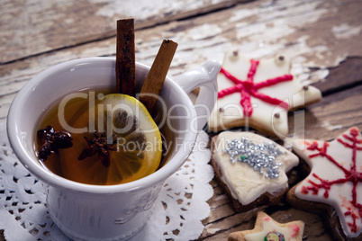 Tea, spices and cookies on wooden plank