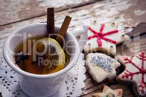 Tea, spices and cookies on wooden plank