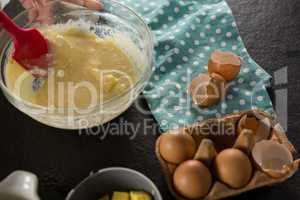 Woman mixing the batter of beaten eggs, milk and butter in a bowl
