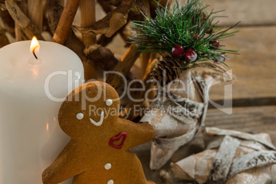 Gingerbread cookie by illuminated candle and star shape decorating