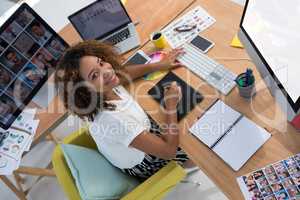 Female executive working over graphic tablet at her desk in office