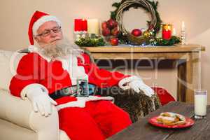 Santa claus relaxing on sofa in living room at home