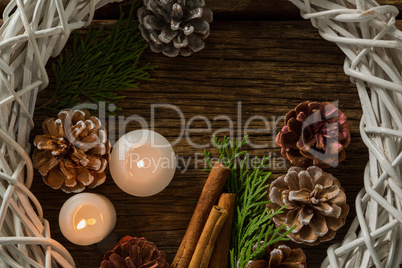 Directly above shot of pine cones with illuminated candles and wreath