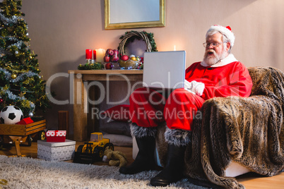 Santa claus sitting and using laptop