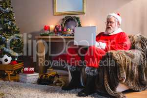 Santa claus sitting and using laptop