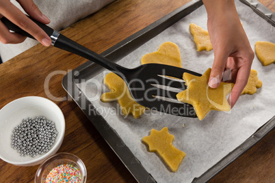 Man placing gingerbread cookies in baking tray