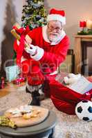 Santa Claus putting presents in christmas bag