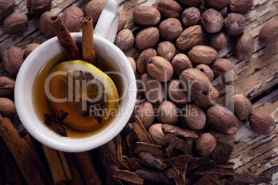 Tea, spices and nuts on wooden plank