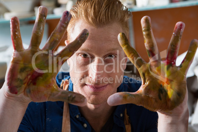 Male potter showing his painted hands