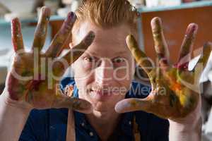 Male potter showing his painted hands