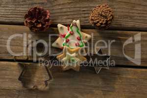 Overhead view of cookies with pine cones and pastry cutters on table