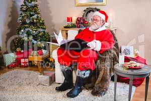 Santa Claus reading a book in living room