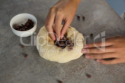 Woman adding chocolate chips into the dough