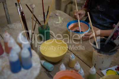 Mid section of girl painting a bowl